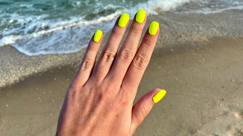 Neon yellow manicure by the ocean