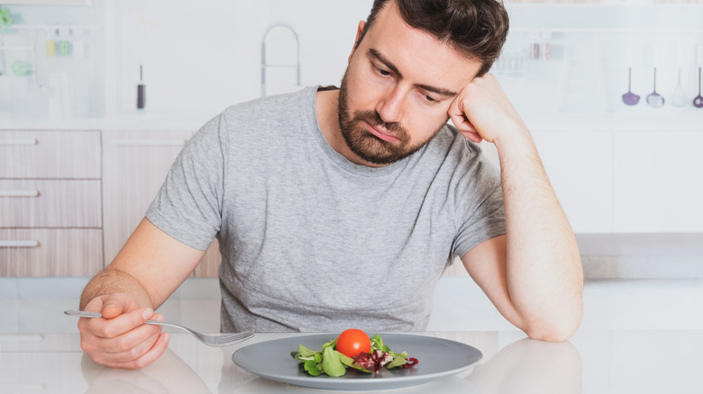 Man looking sadly at food