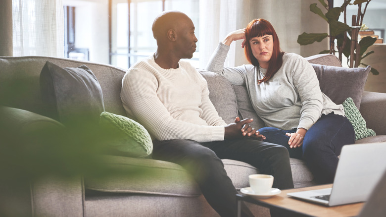 serious couple sitting on sofa