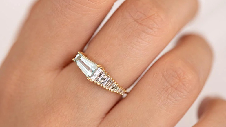 asymmetrical baguette diamond engagement ring on hand