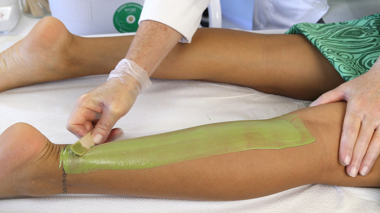 Waxing leg with green wax