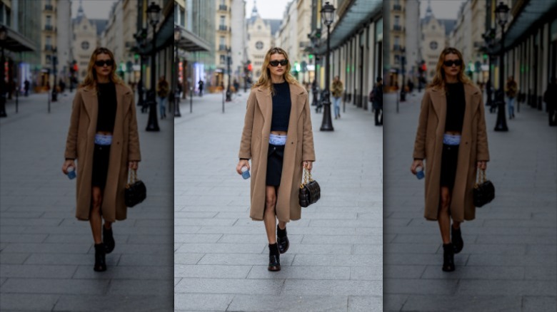 woman with Bottega Veneta black bag with gold chain