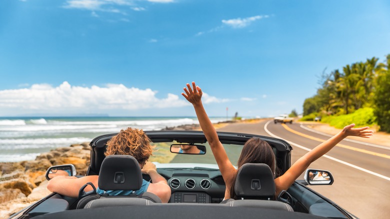 Couple in convertible on vacation 