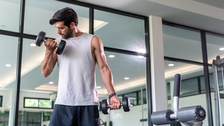 Man lifting free weights at gym