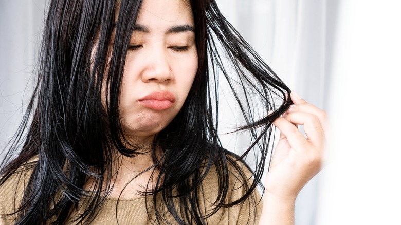 Woman frowning at greasy hair