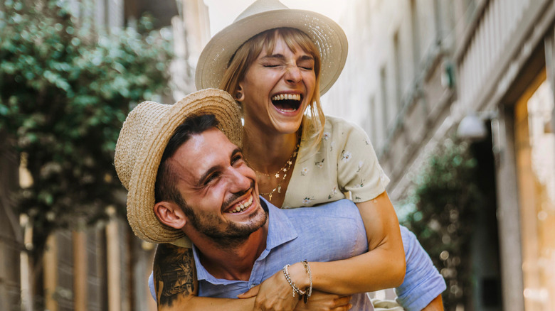 Laughing girlfriend getting piggyback ride