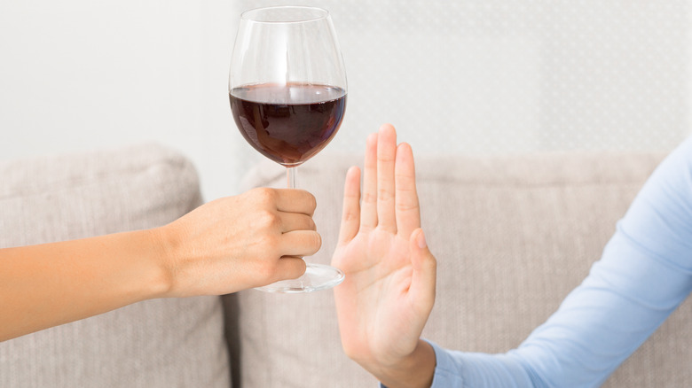 person refusing glass of wine