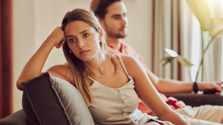 Woman ignores man on sofa