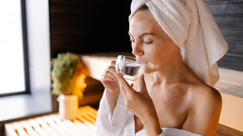 Woman keeping hydrated in sauna