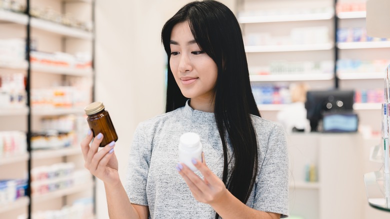 woman looking at pill bottles