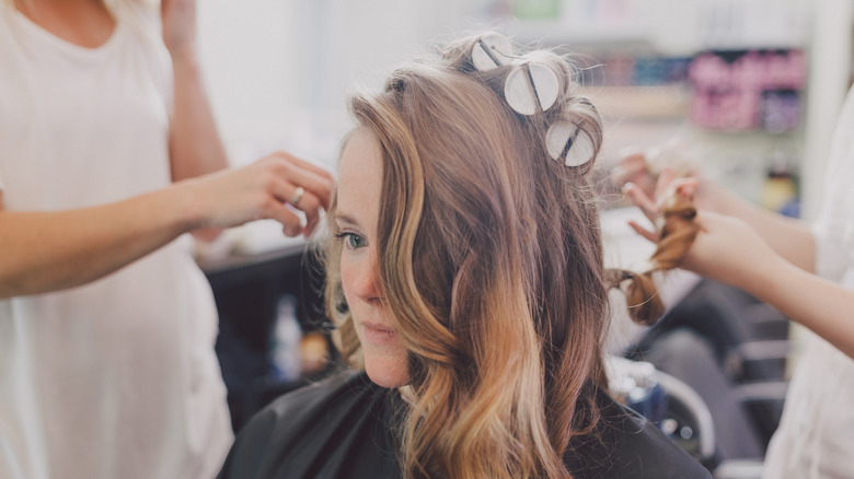 Woman at a salon with rollers in her hair