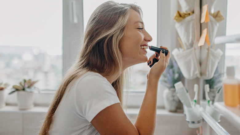 Woman applying lipstick