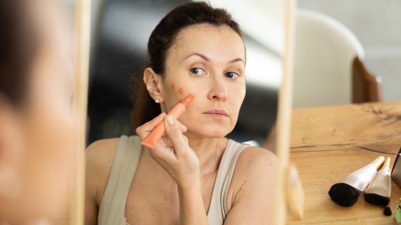 woman applying cream blush