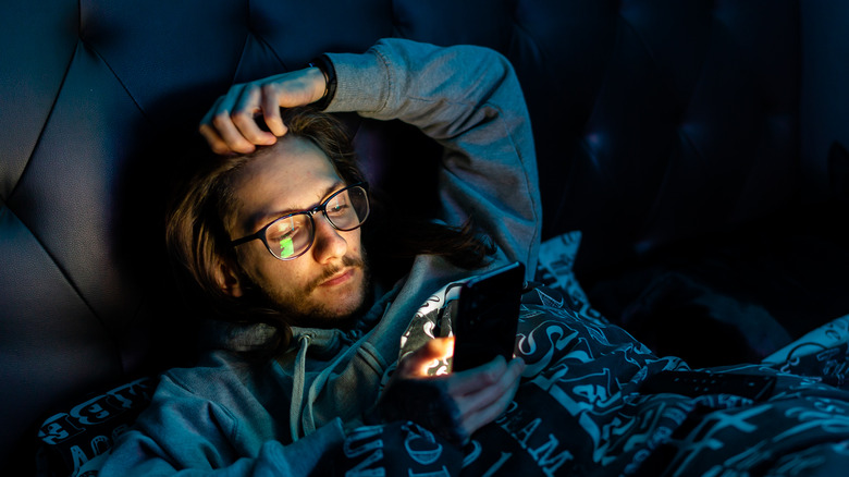 Man using phone in bed