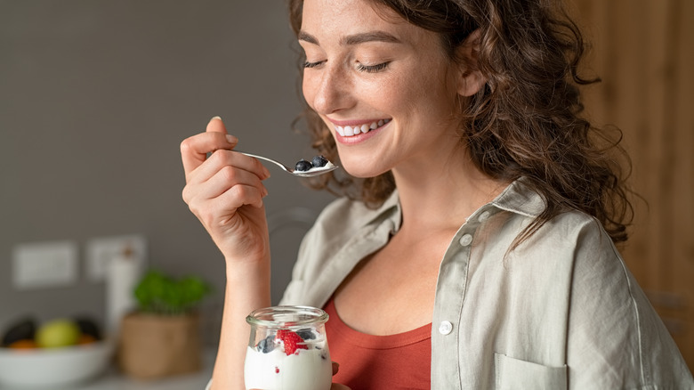 young woman eating yogurt parfait