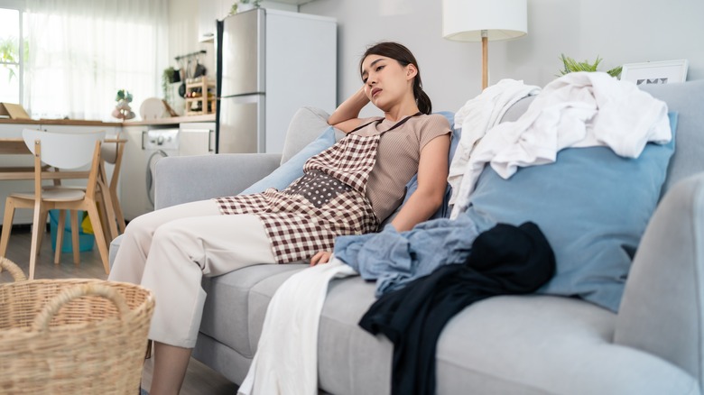 girl sitting with laundry everywhere