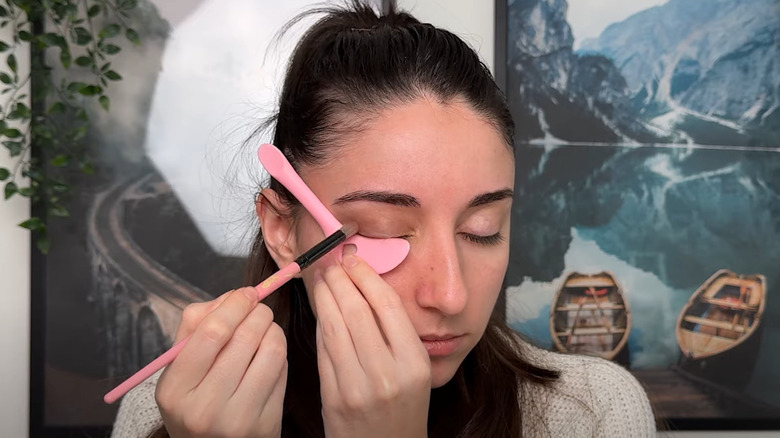 Woman using stencil to apply eyeshadow