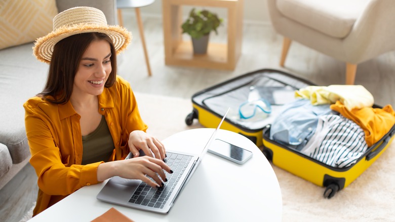 woman booking flight and packing