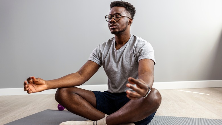 Man meditating on yoga mat