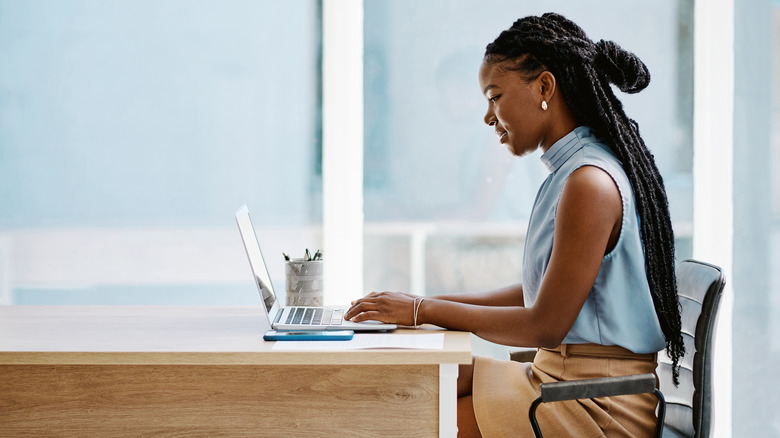 Woman writing at computer