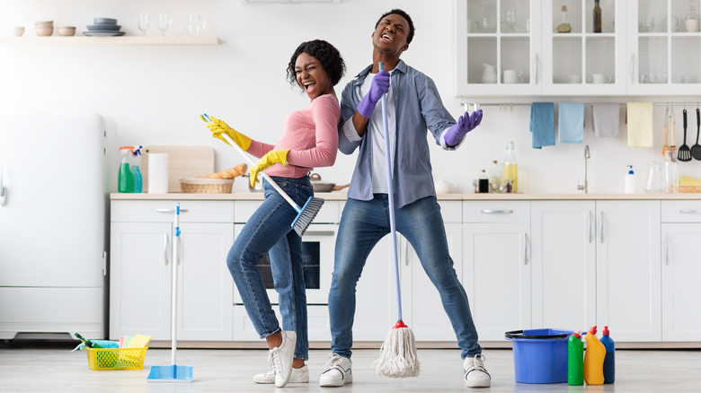Two people singing while cleaning