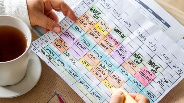 Person making color-coded schedule calendar