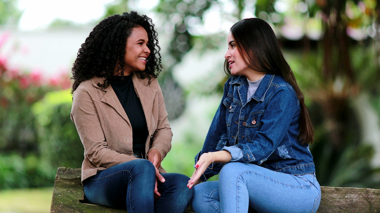 Two people sitting outside talking