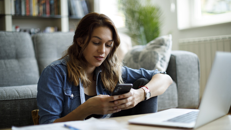 Woman using laptop and smartphone