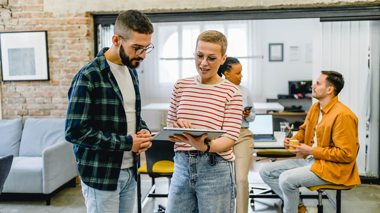 Young individuals collaborating with employees