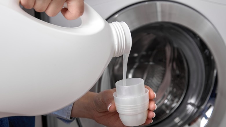 Pouring laundry detergent into lid