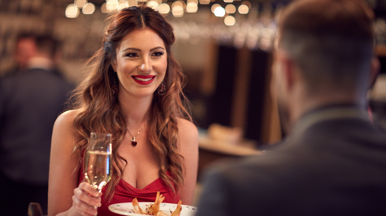 A woman on a date wearing a red dress and red lips