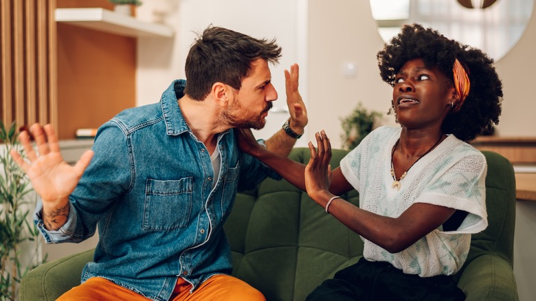 A surprised woman trying to calm an angry man.