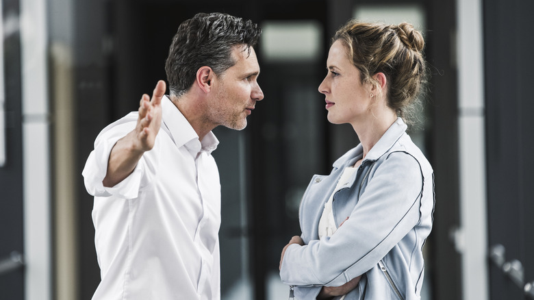 A woman calmly listening to a gesturing man.