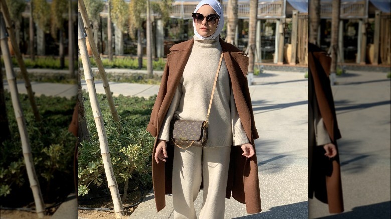 Ghady pairs sweat suit with long brown coat