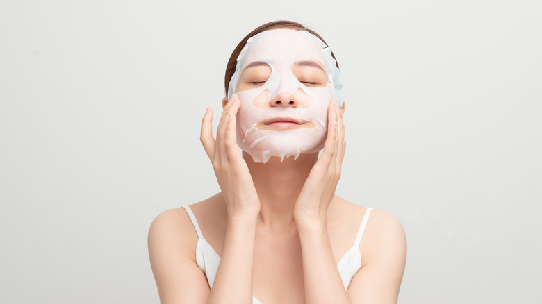 Woman applying sheet mask