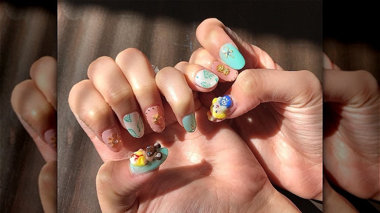 woman's hands with 3d mismatched manicure