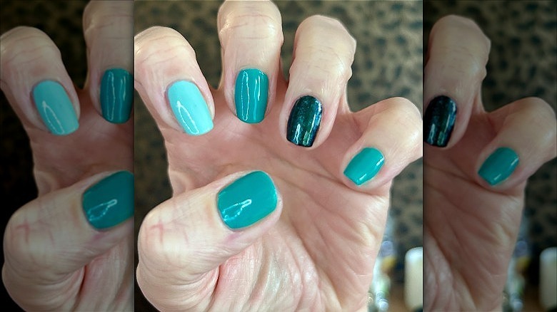 hand with turquoise mismatched manicure