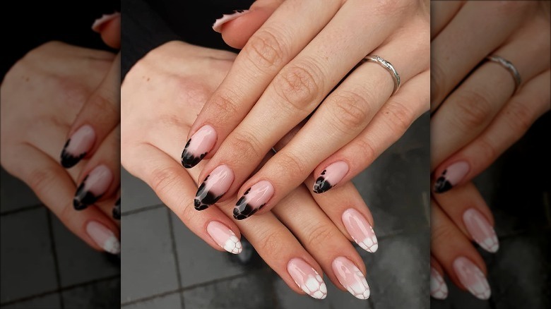 woman's hands with white black mismatched manicure