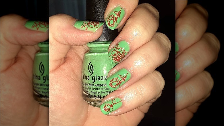 hand with mismatched flower nails