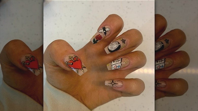 woman's hands with tarot nails design