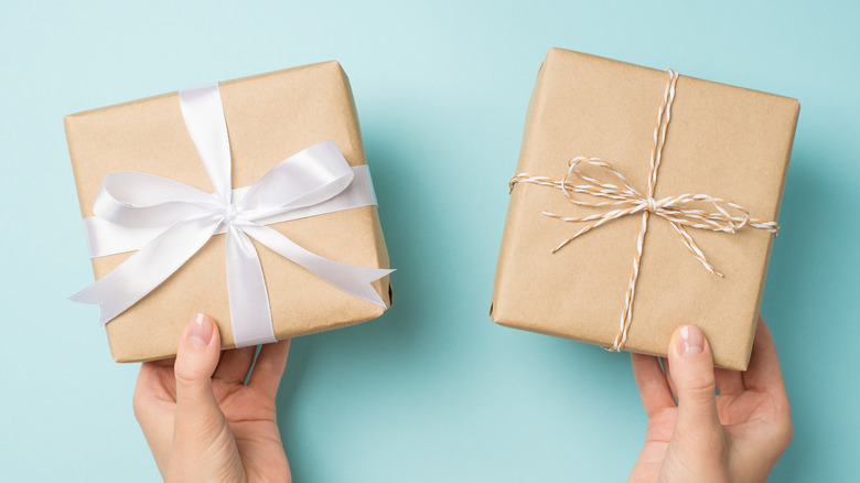 hands holding gifts wrapped in butcher paper