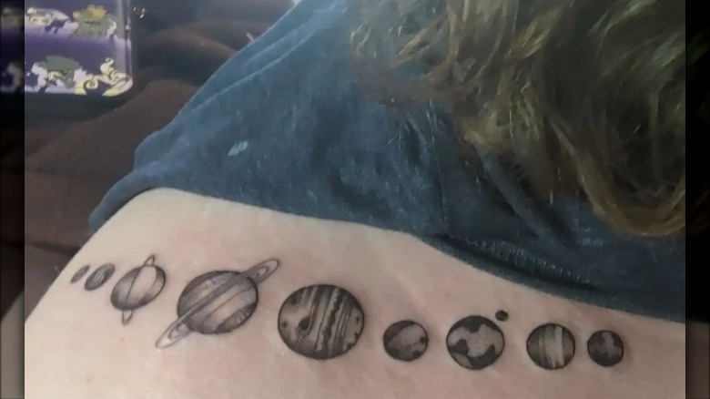 woman with planets collarbone tattoo