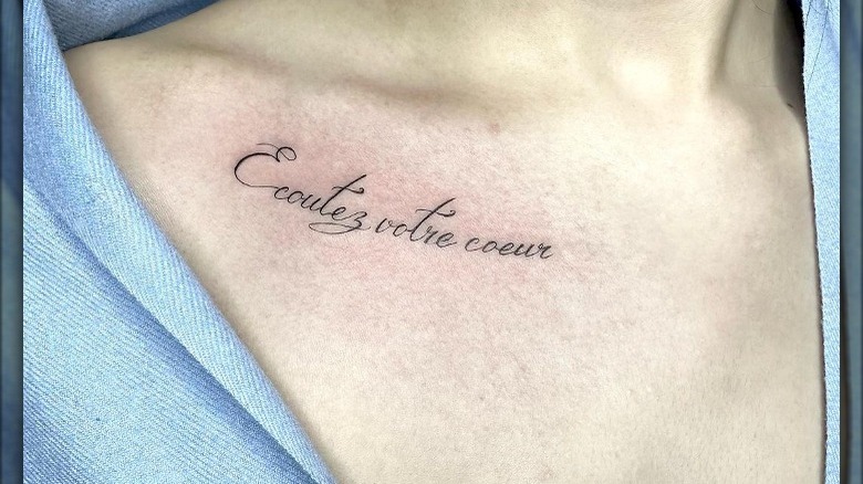 French script collarbone tattoo