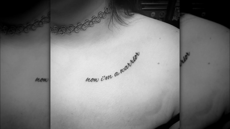 woman with script collarbone tattoo