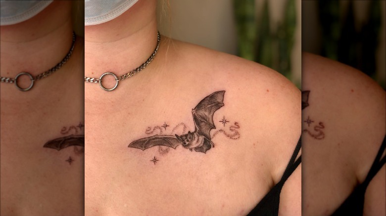 woman with bat collarbone tattoo