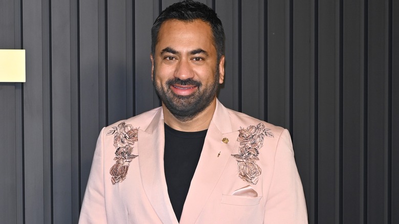 Kal Penn smiling pink suit