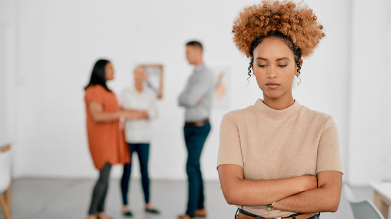 An angry woman avoiding her colleagues.