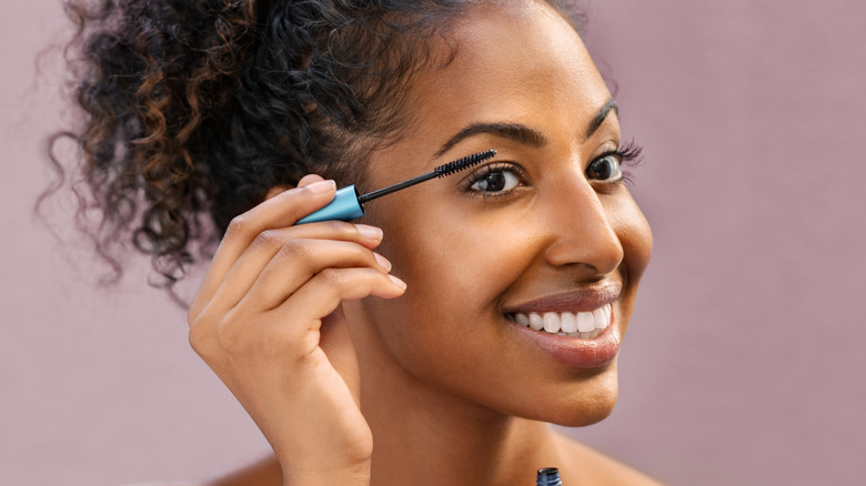 woman putting on mascara