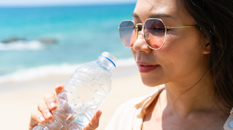 woman drinking water at beach