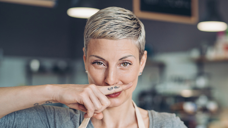 Woman with finger mustache tattoo